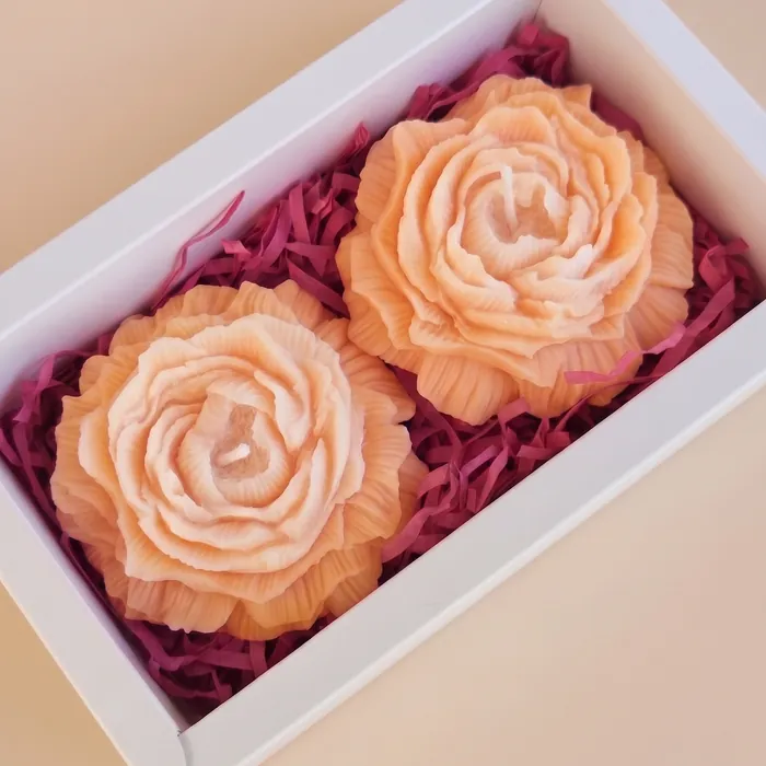 Two orange ombre flower candles in a gift box
